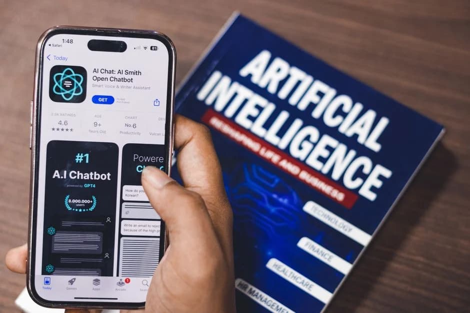 A smartphone screen displays an AI-powered app interface, with a book about artificial intelligence technology standing