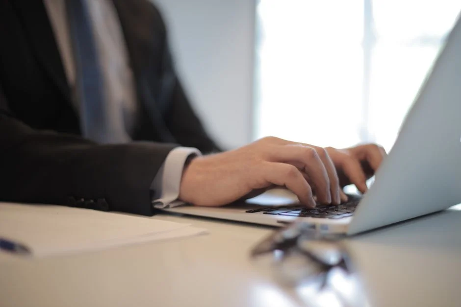 Overhead view of hands typing on a laptop keyboard.