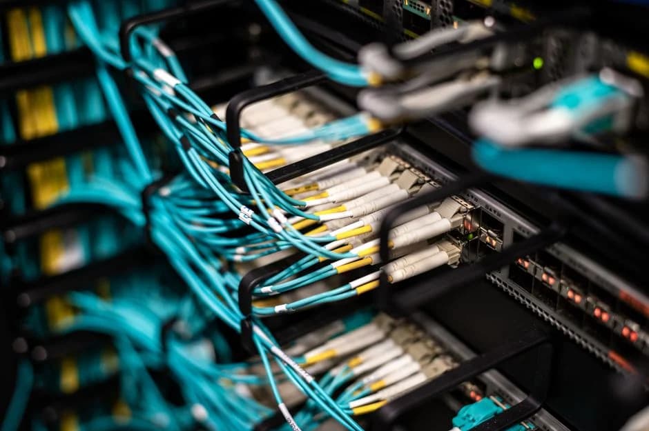 Colorful network cables neatly organized on a wall-mounted patch panel in a modern data center.